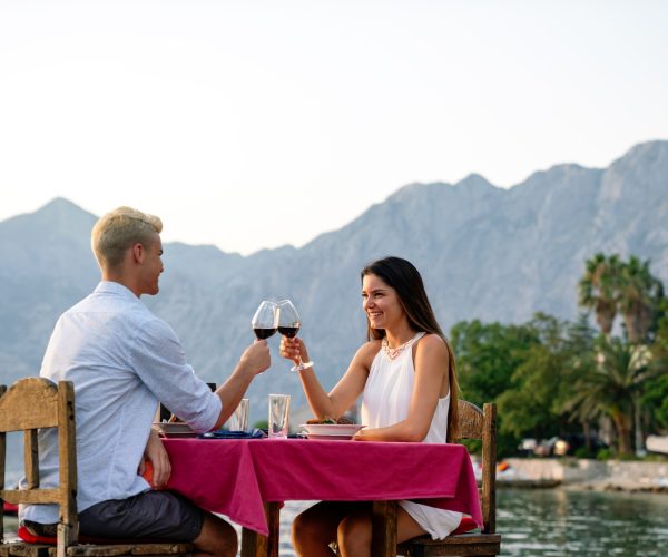 Pareja disfrutando de una cena romántica en un viaje a medida con vistas a la montaña