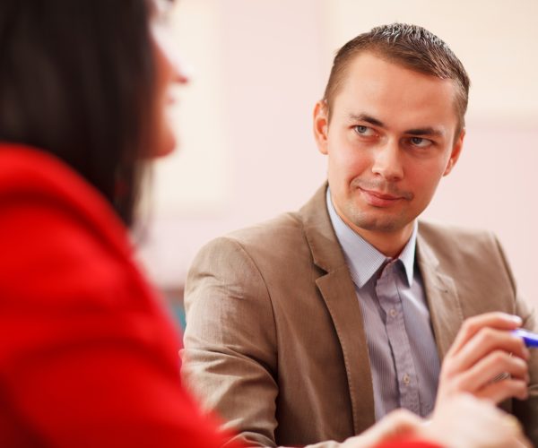 Consultor ofreciendo asesoramiento integral de empresas a una cliente en reunión personalizada